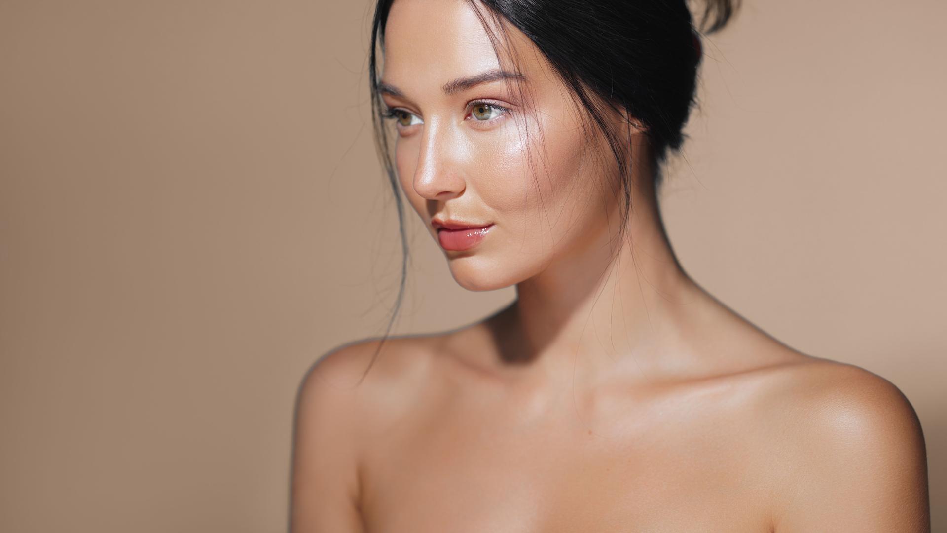 Elegant Asian Model with Radiant Skin Posing in Minimalistic Studio